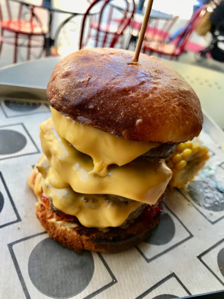 istock Big Cheeseburger / Hamburger with Corn, Cheddar and Parmesan Cheese served with Tray at Fast Food Restaurant. Ready to Eat. 1181382703