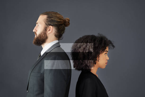 Equal means equal Shot of two corporate businesspeople posing together in studio with gender symbols inserted in the background gender stereotypes photos stock pictures, royalty-free photos & images