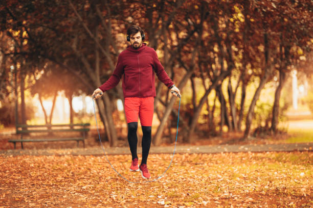 istock Man jumping rope outdoors on sunny autumn morning. 1181384616