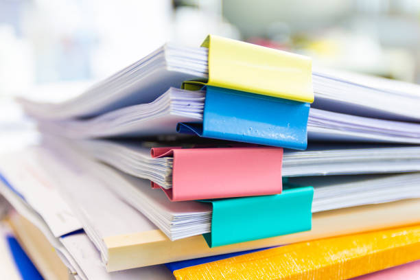 istock file folder and Stack of business report paper file on the table in a work office 1181385007