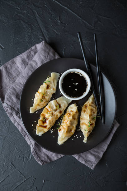 istock Wonton stuffed with soy sauce on a dark table 1181385960
