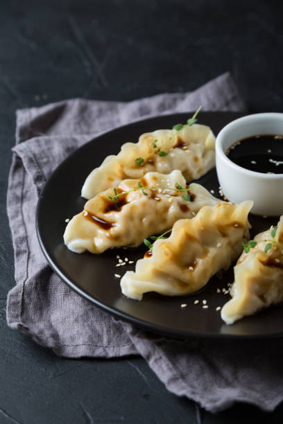 istock Wonton stuffed with soy sauce on a dark table 1181386280