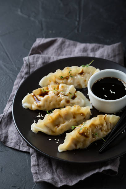 istock Wonton stuffed with soy sauce on a dark table 1181386342