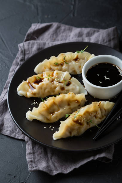 istock Wonton stuffed with soy sauce on a dark table 1181386409