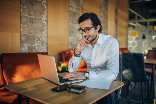 istock Handsome businessman using laptop in cafe 1181388702