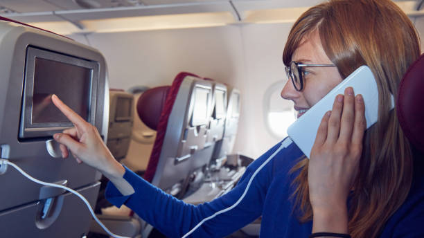 istock Woman using cellphone in modern airplane seat. 1181390685
