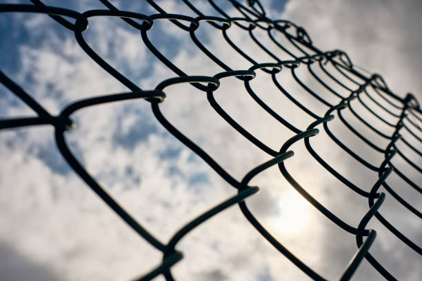 istock Chain link fence against a cloudy sky background. 1181390856