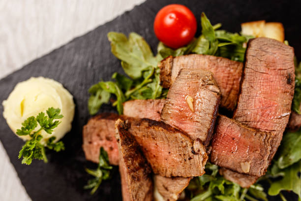 delicioso filete tagliata en tabla de piedra negra - fillet meat portion fillet steak fotografías e imágenes de stock