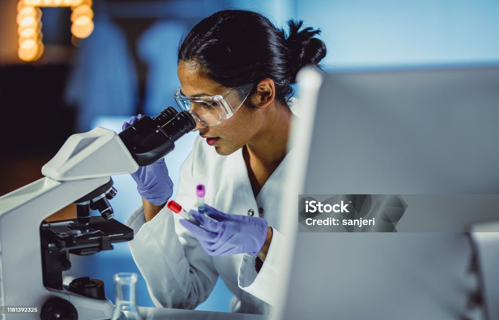 Young Scientist Looking Through a Microscope Laboratory Stock Photo