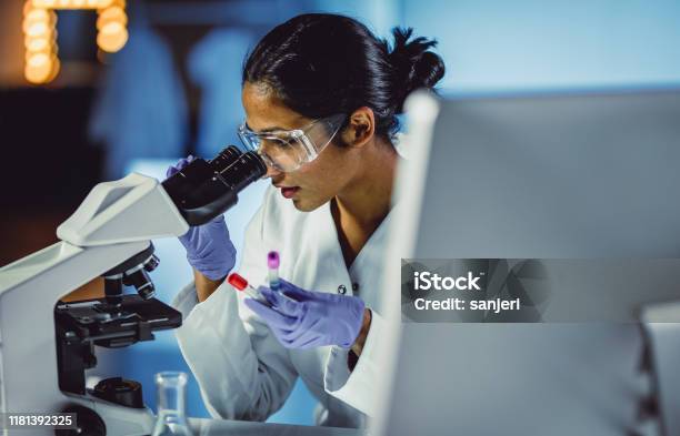 Young Scientist Looking Through A Microscope Stock Photo - Download Image Now - Laboratory, Scientist, Research