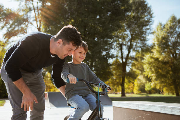 istock Father Learning his son to ride a bicycle 1181393001