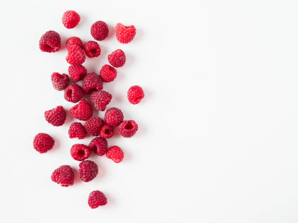 Heap of raspberry on white, copy space right Heap of fresh ripe red raspberries on white background. Raspberry with copy space for text or design. Top view or flat lay. raspberry stock pictures, royalty-free photos & images
