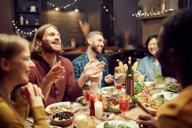Photo of People Laughing at Dinner Table