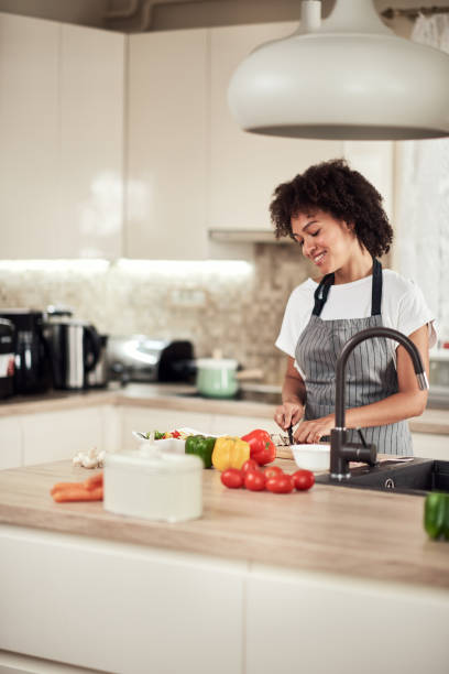 istock Woman cutting mushrooms while standing in kitchen. 1181396576