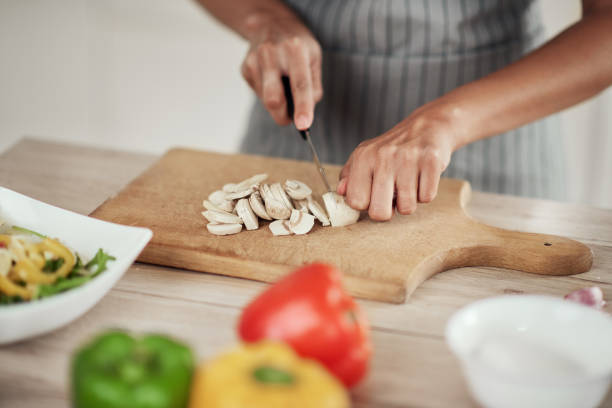 istock Woman chopping mushrooms. 1181396735