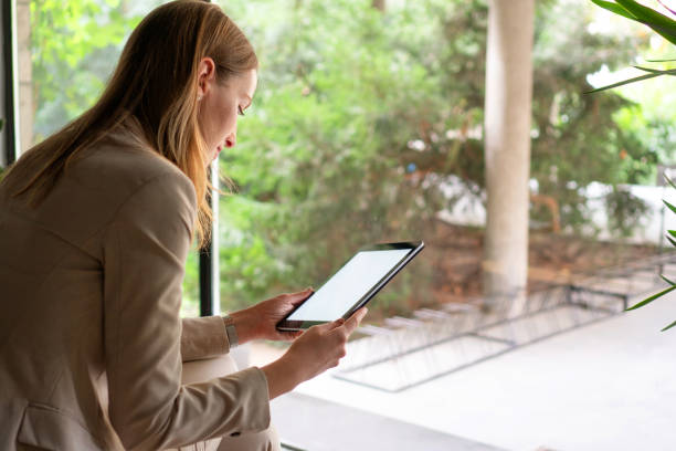 istock Young woman typing on digital tablet 1181408151