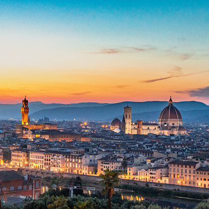Aerial view of rooftops, buildings and of the Florence cathedral, also called Duomo di firenze. This view is shot at sunset.
