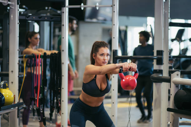 istock Young woman doing kettlebell exercises at gym 1181408598