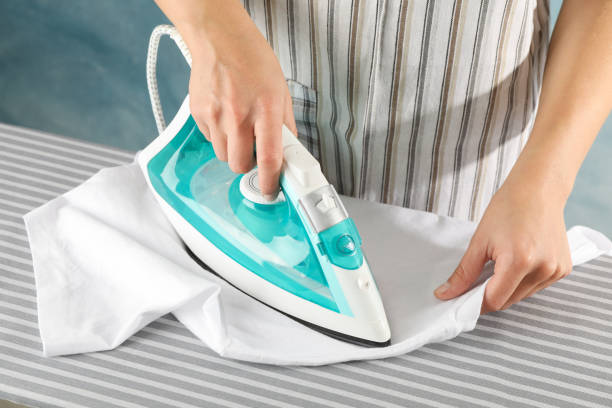 istock Young woman ironing on board, close up 1181409416