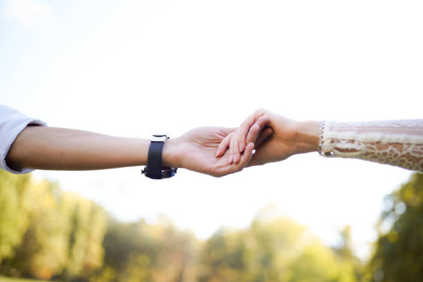 couple holding hands on nature background with copy space