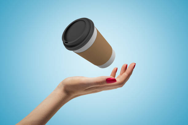 istock Female hand with coffee paper cup on blue background 1181411007