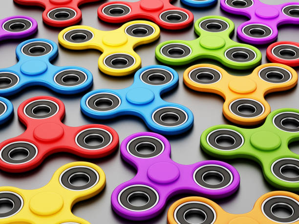 multi-gekleurde fidget spinners geïsoleerd op zwart - handspinner stockfoto's en -beelden
