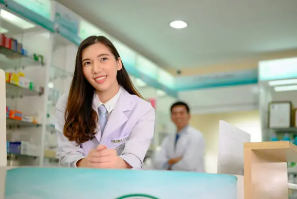 woman pharmacist in the welcome counter in pharmacy drug stroe