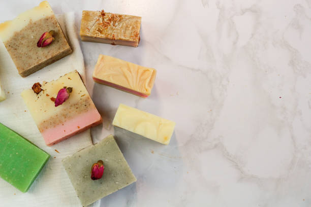 istock Handmade multicolored soap with honey. lavender, mint, herbs and rosebuds on a marble background with a space for text. Spa soap for face and body treatments flat lay style 1181413882