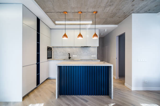Modern kitchen front view Modern kitchen, grey facade, three lamps over kitchen island, integrated kitchen equipment, modern blue kitchen island. wide shot stock pictures, royalty-free photos & images