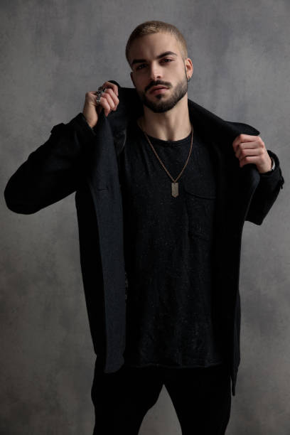 istock Tough young man adjusting his black long coat 1181414247