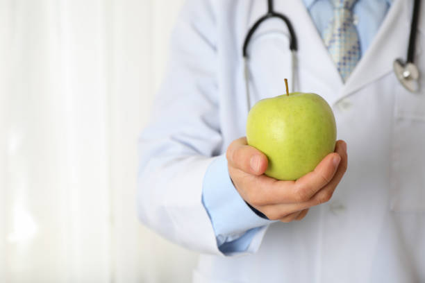istock Doctor with apple and stethoscope, close up and space for text 1181414354