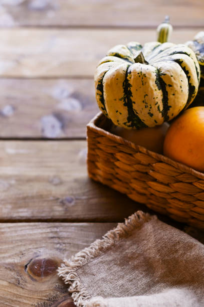 istock Different Thanksgiving Mini Pumpkins on a rustic wooden table. Thanksgiving concept. Autumn, Harvest wicker basket. Napkin is old. Focus is selective. 1181414467