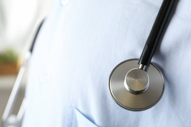 Stethoscope on medical gown, close up and copy space