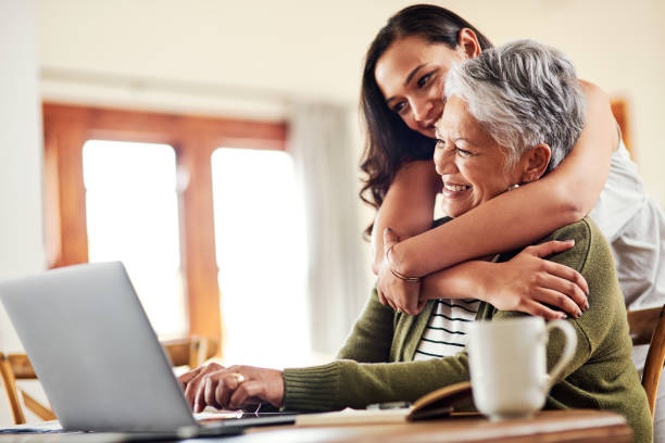 I am always so proud of you Cropped shot of an attractive young woman hugging her grandmother before helping her with her finances on a laptop pension photos stock pictures, royalty-free photos & images