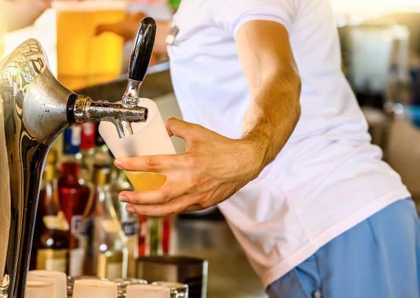 istock Bartender pours the beer into a glass from the tap. 1181417640