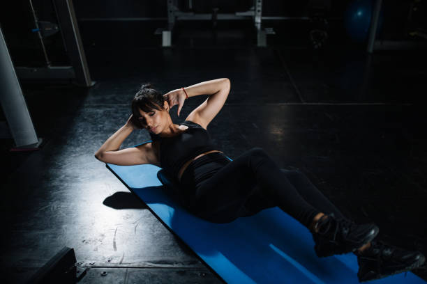 istock Woman lying on her back doing cycling abs exercise 1181421776