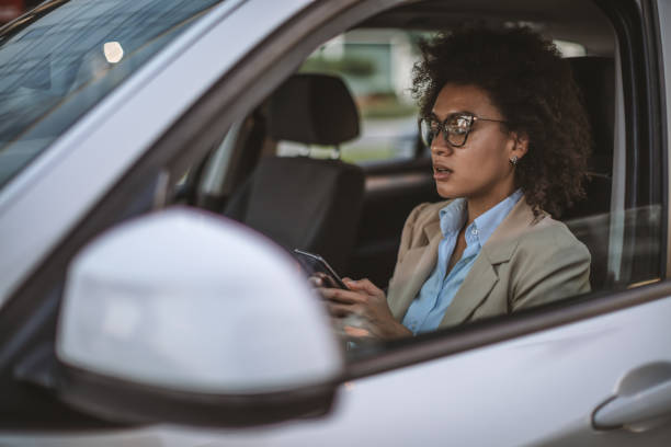 istock Business woman using smart phone in a car 1181422117