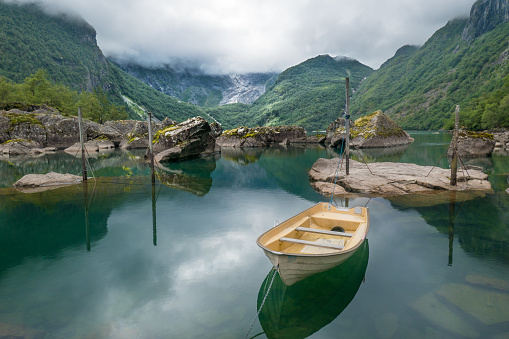The lake at the end of Uske Valley (Uskedalen) in Folgefonna nature reserve, Norway. Rowing boat and rocks in the foreground