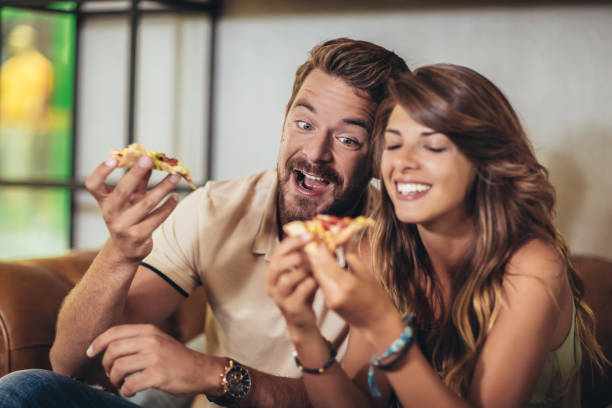 istock Happy young couple eating pizza in a restaurant. 1181423071