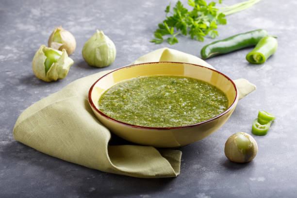 томатильо сальса верде. чаша острого зеленого соуса на сером столе, мексиканская кухня. - salsa hot sauce mexico condiment стоковые фото и изображения