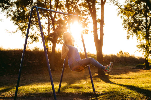 istock Woman on a swing in a park 1181424421