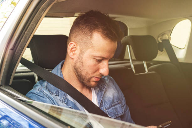 istock Young man inside a car holding a mobile phone. 1181426467