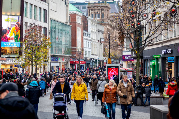 Busy Christmas Shopping in Liverpool Liverpool, UK - December 27, 2018: A busy pedestrianised outdoor shopping street in Liverpool's city centre. People can be seen walking and a busker can be seen on the left of the photograph. liverpool one stock pictures, royalty-free photos & images