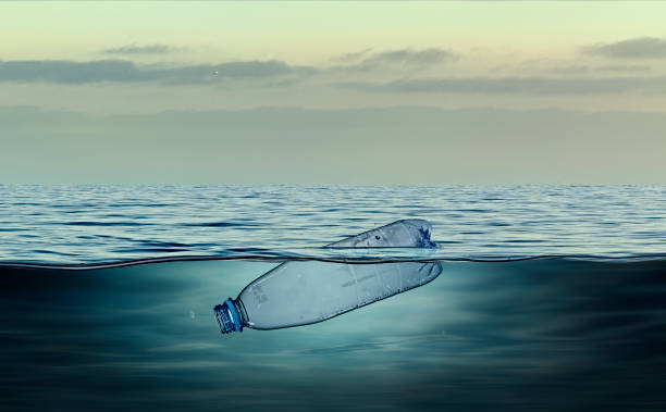 botella de plástico, contaminación que flota en el océano - plástico fotografías e imágenes de stock