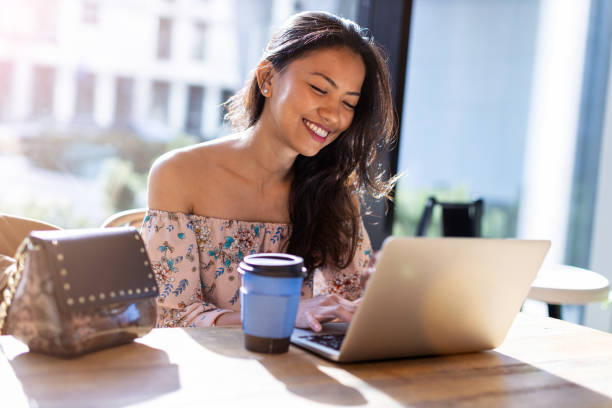 beautiful filipino woman using laptop at cafe - filipino ethnicity asian ethnicity women computer imagens e fotografias de stock