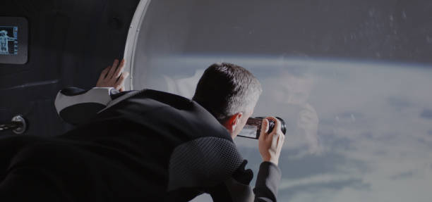 istock Astronaut filming Earth from spaceship 1181432210