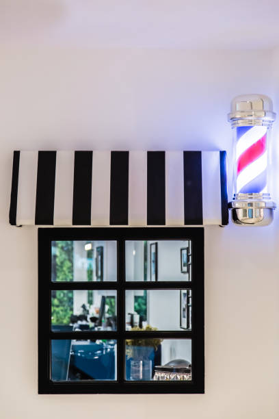 small barbershop window on white wall facade view