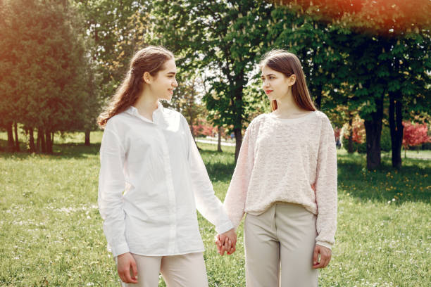 istock Elegant and stylish sisters in a spring park 1181442032