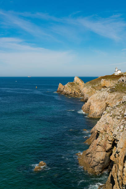 gezackte felsige küste mit tiefblauem ozean und weißem leuchtturm - atlantic coast flash stock-fotos und bilder