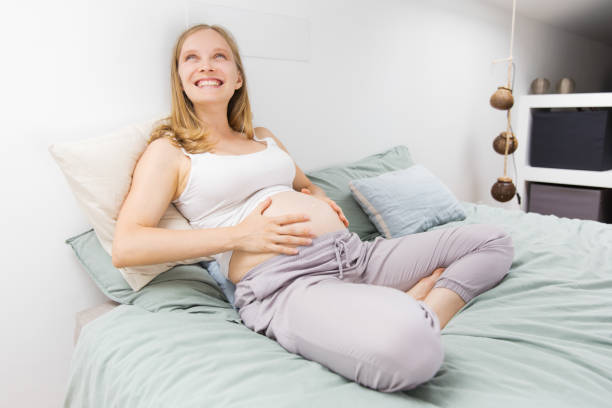 istock Joyful expectant mother resting in bed 1181442533